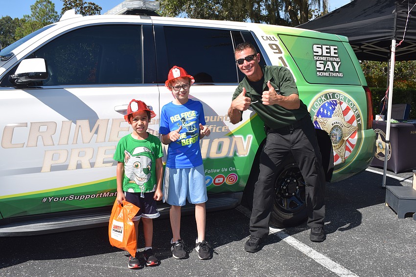 Bradenton 4-year-old Joshua Darby and 8-year-old Zachary Darby learn about the Manatee County Sheriff's Office from Deputy Tom Kaczmarek.