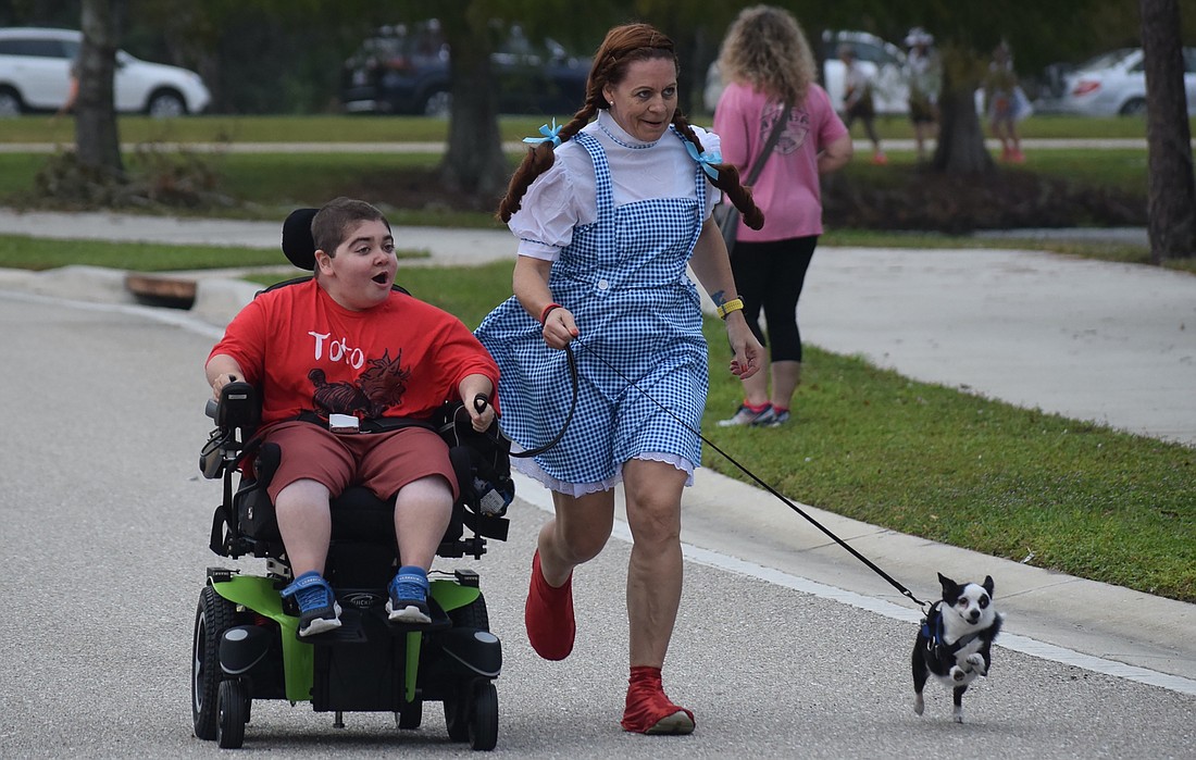 Grayson Tullio, Monika Oberer and Grayson's dog Panda head to the finish line of the 2022 Boo Run 5K. They dressed in a "Wizard of Oz" theme.