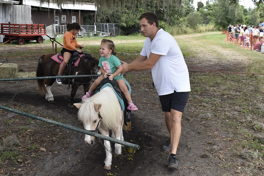 Capri Trukhlinskry, 3, enjoys the pony ride with help from her father, Bogdan Trukhlinsky.