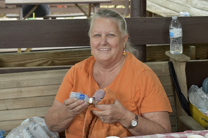 Clancey Hernandez cares for one of the farm's 2-day old piglets, which was rejected by its litter of 8 due to its small size.