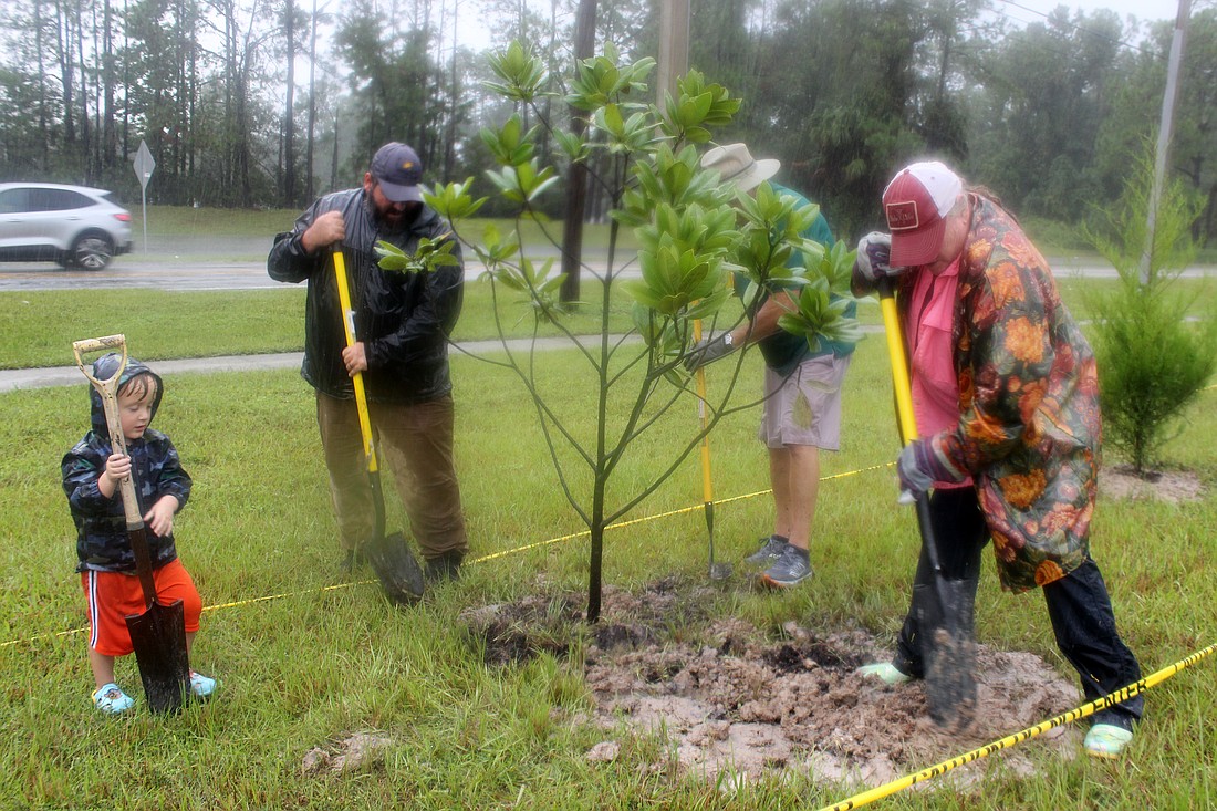 Volunteers help plant trees around Tymber Creek's retention pond. Photo courtesy of Pat Kuehn