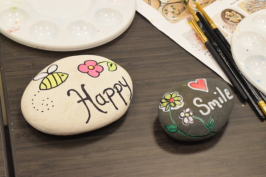 Braden Woods' Kathy Varsalona paints rocks with positive messages on them.