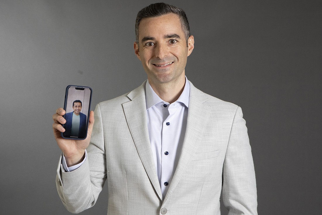 Matthew Ram holding a picture in his phone of his mentor, Santosh Govindaraju, CEO of Convergent Capital Partners.