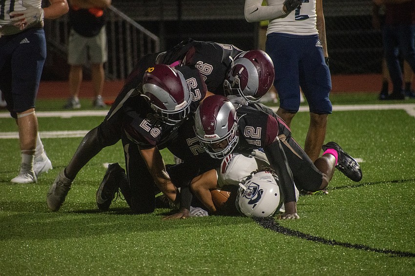 The Rams' defense puts CAI running back Antwan Raymond on the ground.