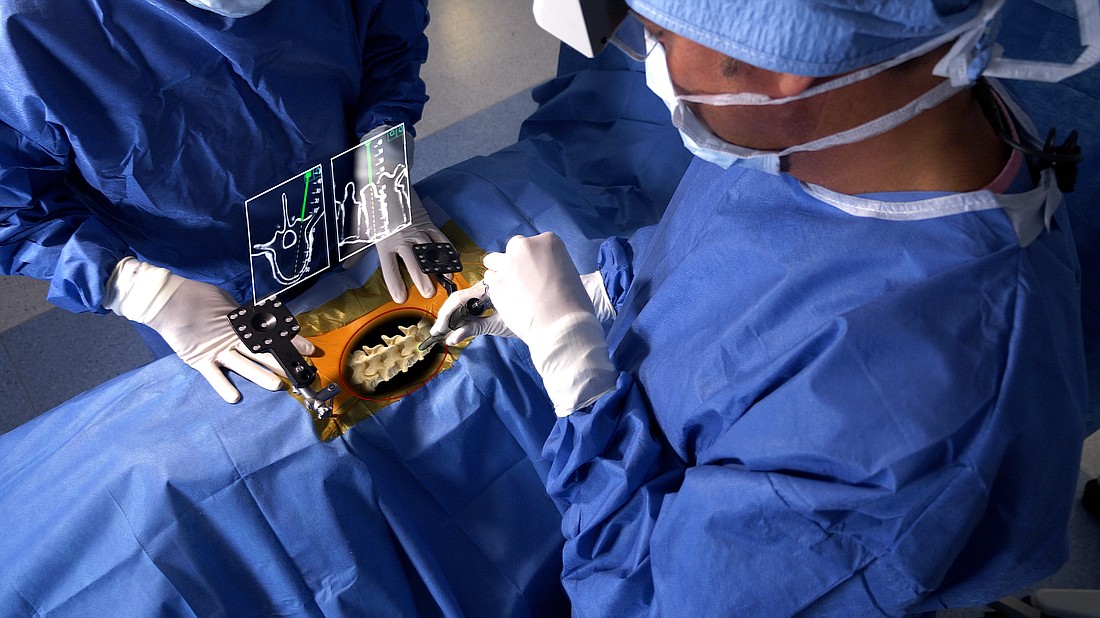 An overhead view of a spinal surgery using Augmedics' xvision augmented reality technology.