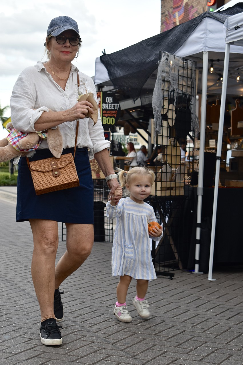 Jody Weniger walks her granddaughter Louella Leavitt through the night market at UTC.