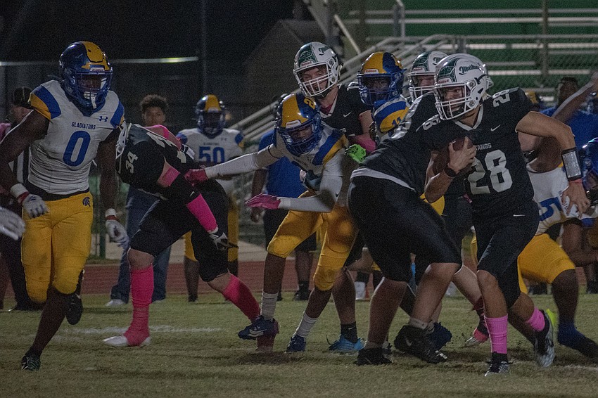 Lakewood Ranch sophomore quarterback Liam Fernandez (28) bursts through the Gibbs defense.