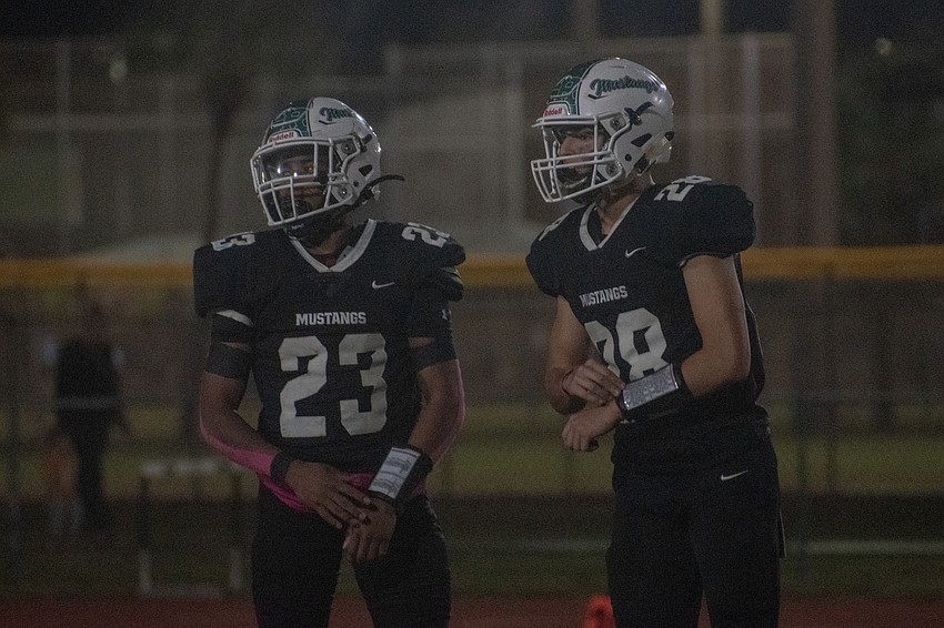 Lakewood Ranch junior running back Cullen McRae II (23) and sophomore quarterback Liam Fernandez (28) gets signals from the sideline.