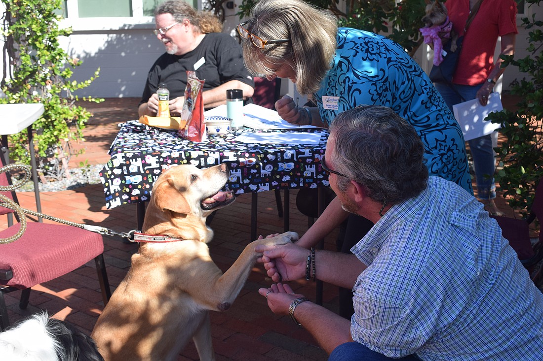 Rev. Brock Patterson blessing Mike and Lauren Ehlers's dog Tucker.