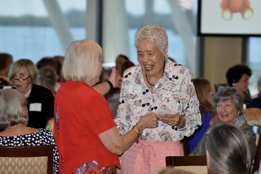 President Sandy Slaminko presents a prize to Betty Venable, a winner of the silent auction.