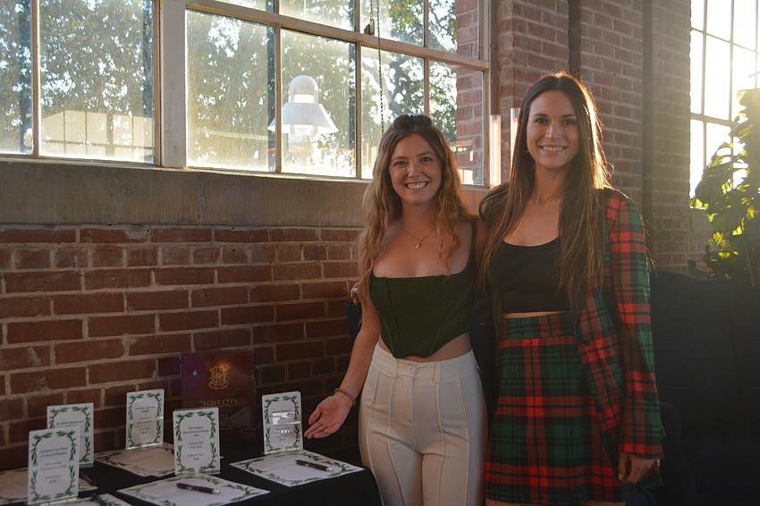 Annie Miller and Zoe Austin oversee a silent auction table.