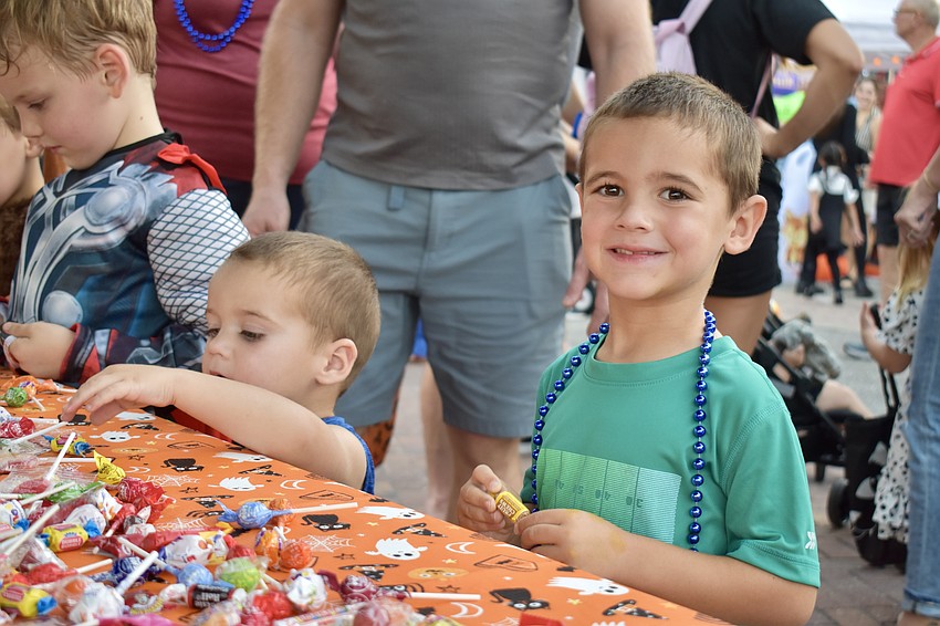 Crew and Knox Taake trick or treat at a table set up by Bob Boast Volkswagen.