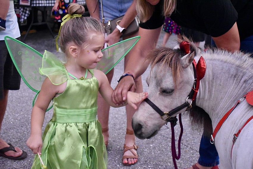 Julia Slimick, 2, pets Fabio, a miniature horse, at BooFest.