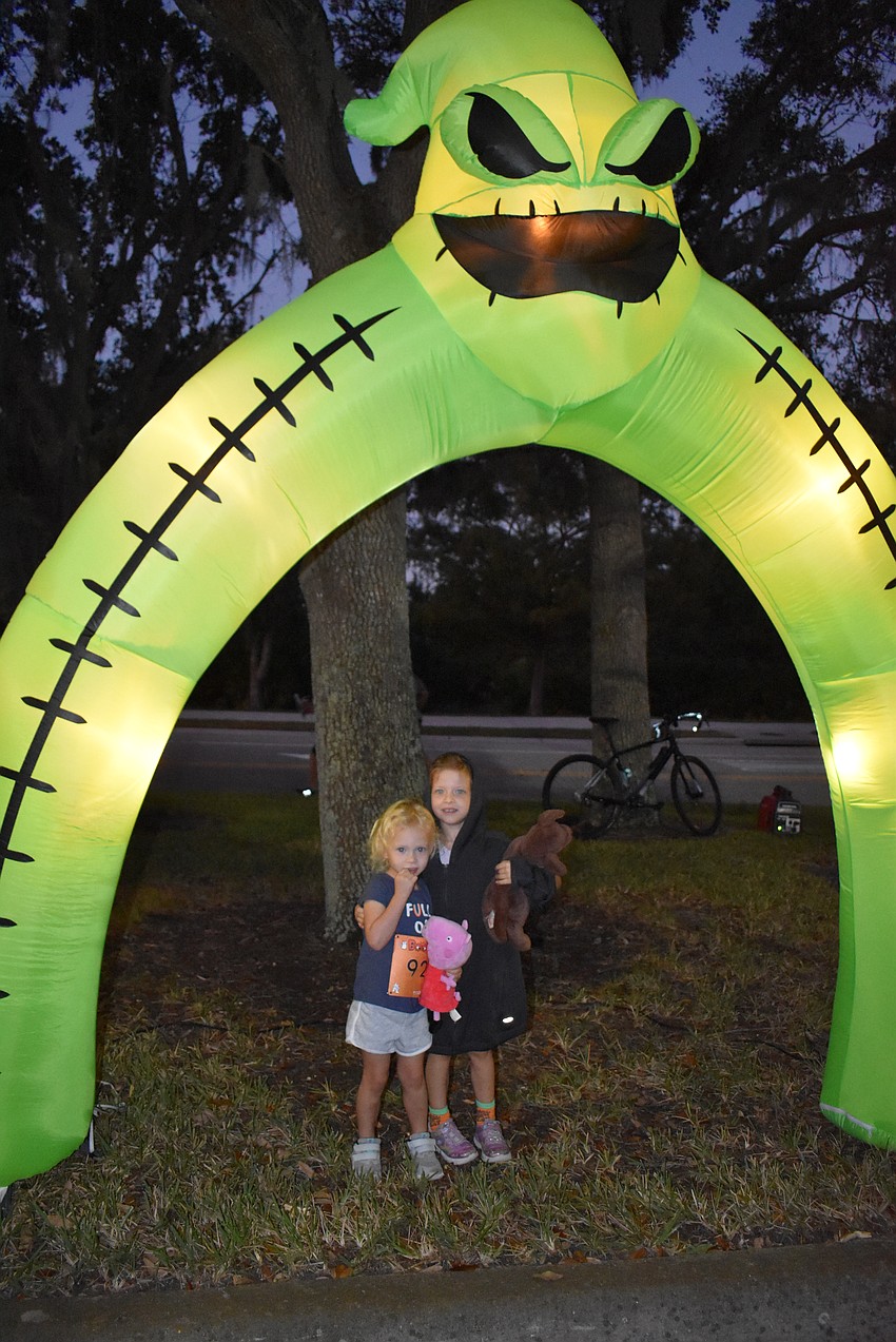 Sarasota's Charlotte Cook, 2, and Savannah Cook, 4, prepare for the Boo Run before the sun comes up in Lakewood Ranch.