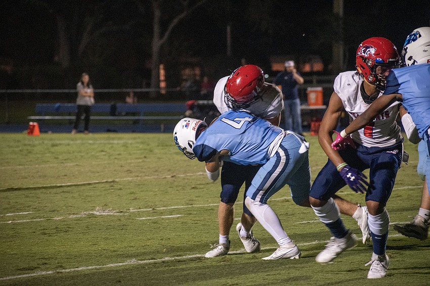 ODA senior Jack Meyers (4) puts a hit on All Saints' Academy senior Aidan Barfield.