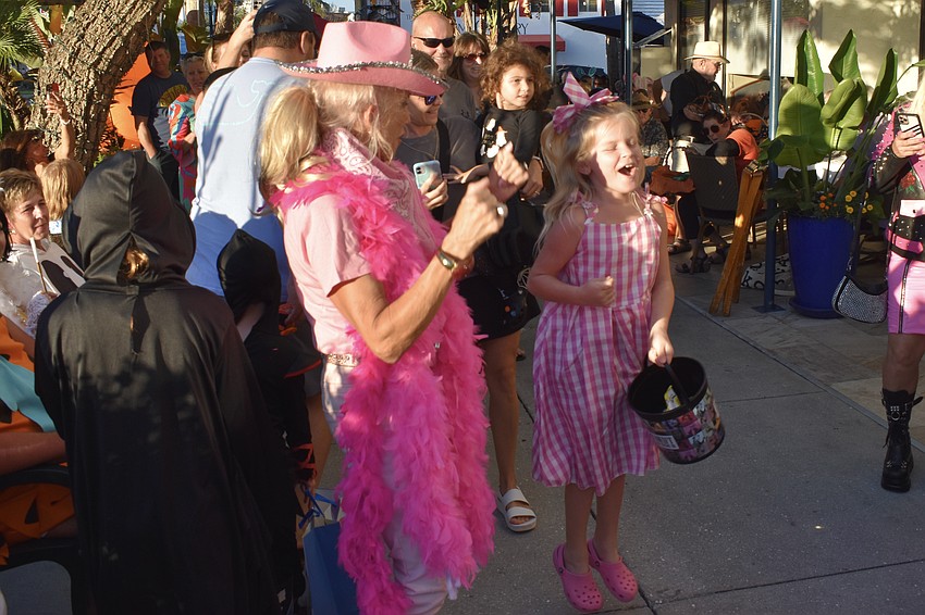 Marcia Gutridge of Longboat Key Club tennis and Clare Hasbrook, 8, jump up and down and chant, 