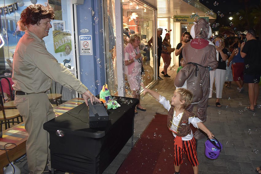 Rick Almarode of Ben and Jerry's provides a flow of bubbles that draws the attention of Arlo Citak, 3.