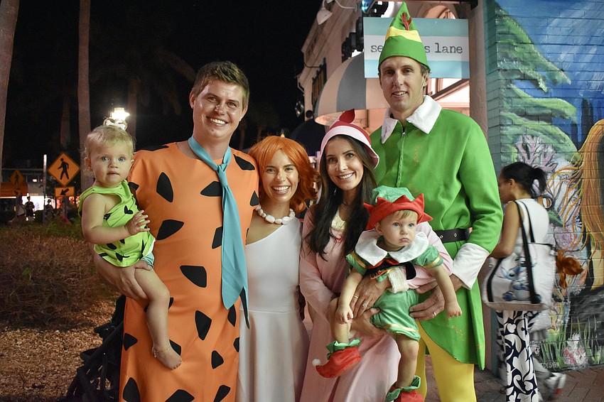 Zamora Quillen, 1, Lucas Quillen and Erica Quillen dressed as Pebbles, Fred, and Wilma Flintstone, while Kyela Jendelund, Aiden Jendelund, 1, and Robert Jendelund dressed as Jovie, Susie, and Buddy from 