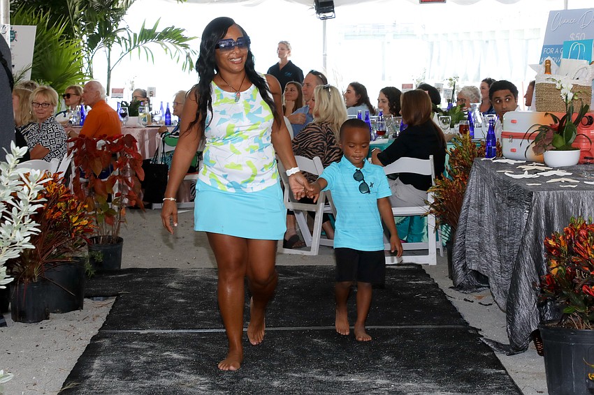 Katressa Wilson walks the runway with her grandson, Demetrez Buckley, 5, at the Children First Flip Flops & Fashion event.