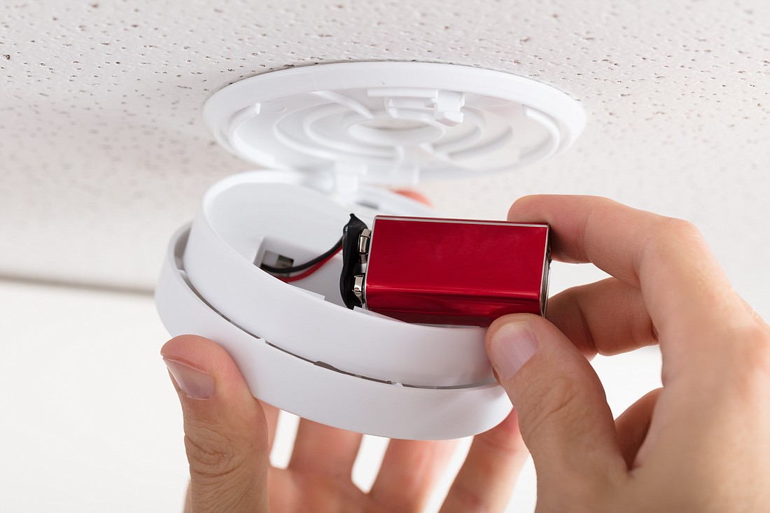 Changing the battery in a smoke detector. Photo from Adobe Stock