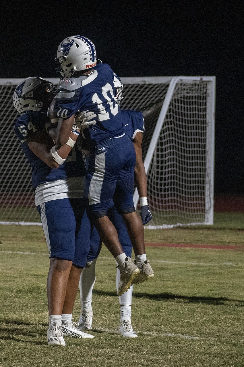 Bulls senior Jerone Turner (10) celebrates a touchdown run with sophomore offensive lineman Caiden Lee (54).
