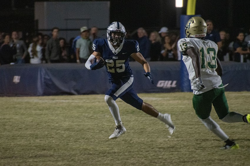 Bulls senior Eloy Serrata (25) runs back an interception against George Jenkins High, trying to avoid a tackle from Eagles senior Tyvion Buford (13).