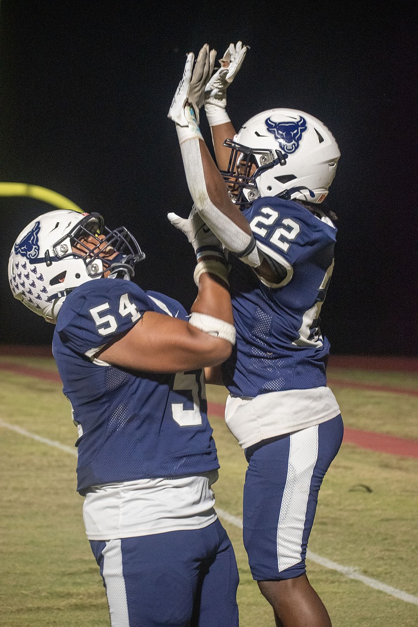 Bulls sophomore Caiden Lee (54) celebrates a touchdown run from junior Jermaine Edwards (22).