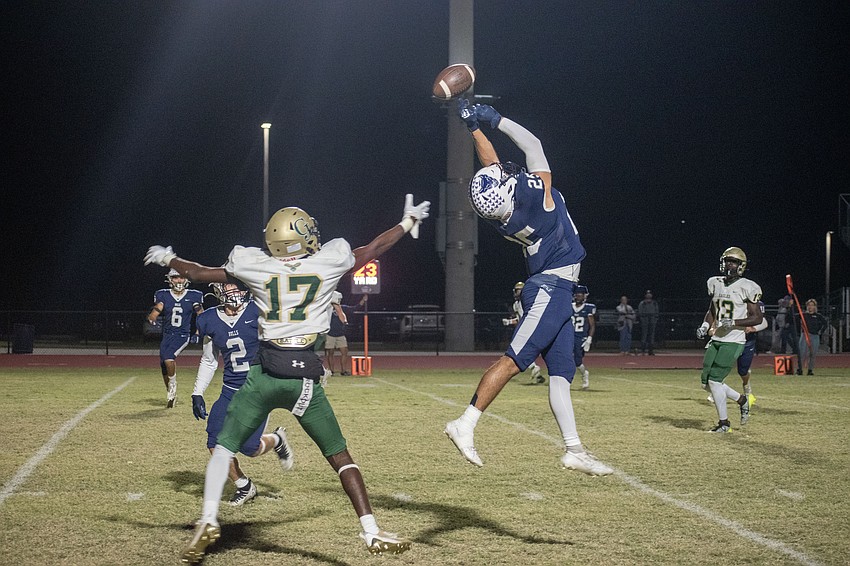 Bulls senior Eloy Serrata (25) tips a pass intended for George Jenkins sophomore Mark Cash (17).