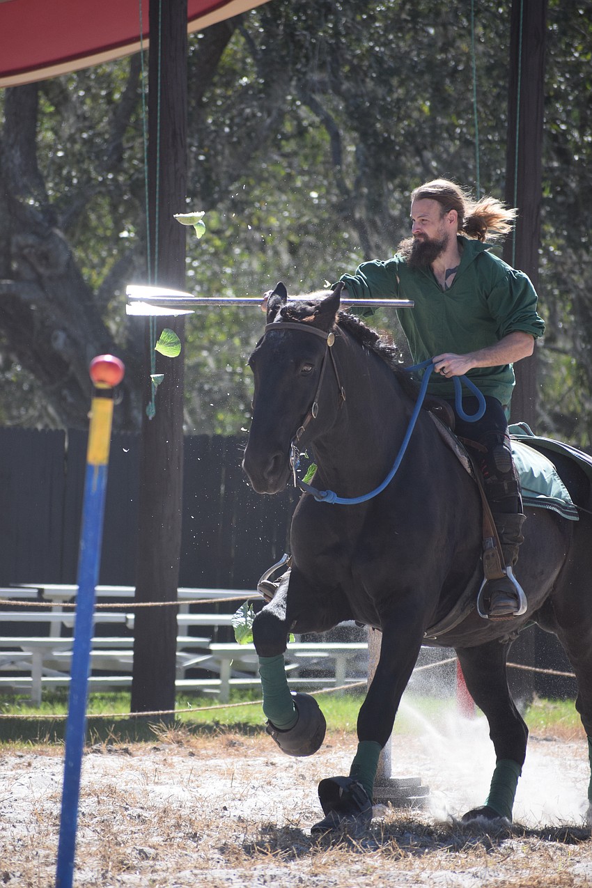 Sam Kuecker slices a cabbage while riding Abraham during the hunting games.