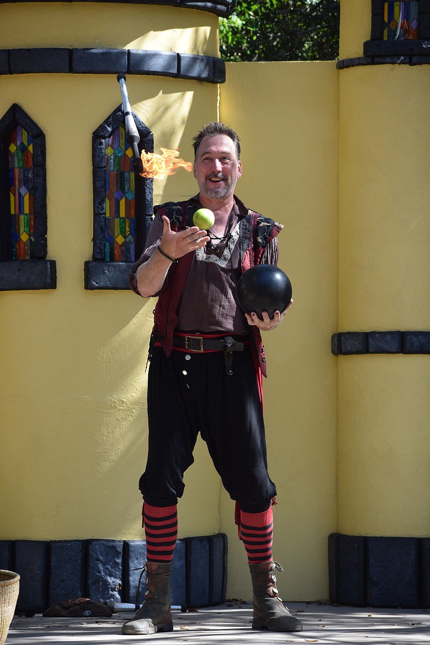 Brian Howard, also known as Broon, juggles fire, an apple and a bowling ball.