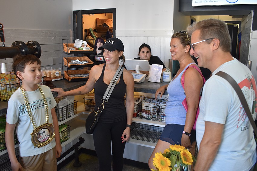 Ivan Gorodnitchev, 10, and Erin Shriver discuss Gorodnitchev's victory with store customers Paul Williams and Shannon Jones.