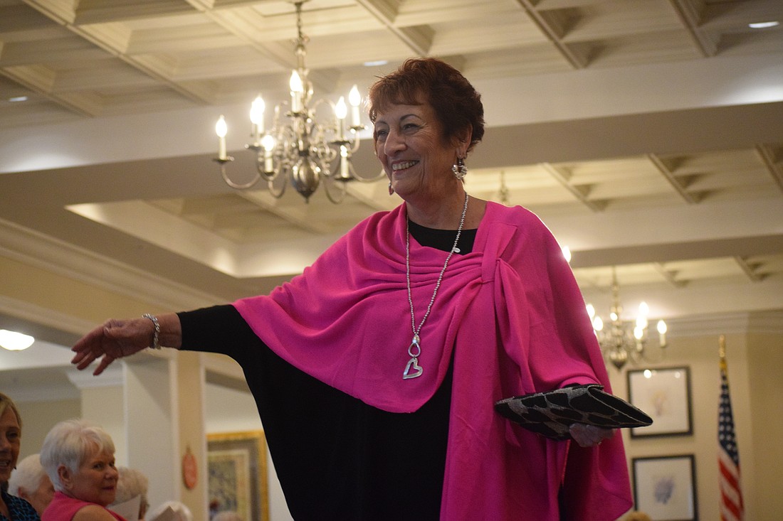 MaryAnn McWilliams waves to friends as she goes down the runway