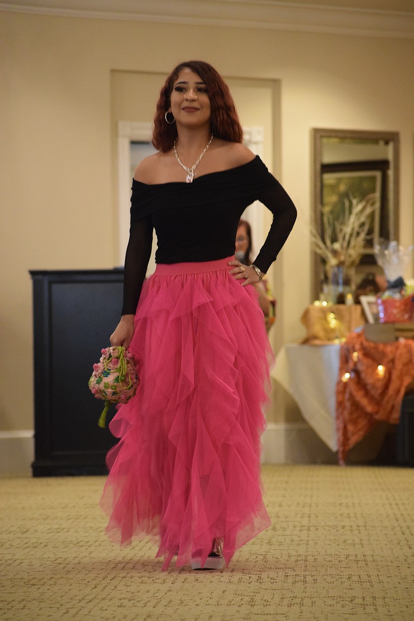 Emely Trinidad with PACE Center for Girls struts down the runway as people look at her outfit in awe.