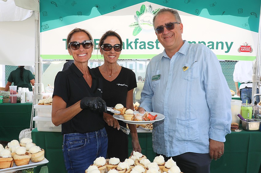 Twins Terri King and Patti Corcoran serve fresh cinnamon buns to USF's Communications and Media Relations Officer Marc Masferrer.
