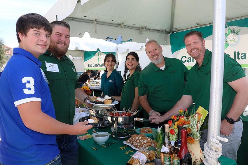 Xavier and Todd Hughes are filling their plates. Karyna Haefele, Virginia Orellana, Jason Lalloz and Peter Barrett serve up food from Carrabba's Italian Grill.