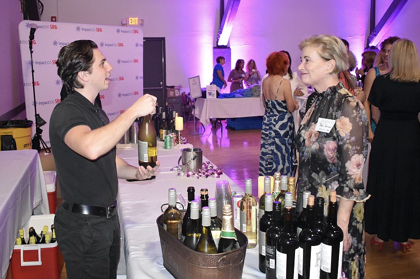 Joey Zampino offers wine to Pati Knox.