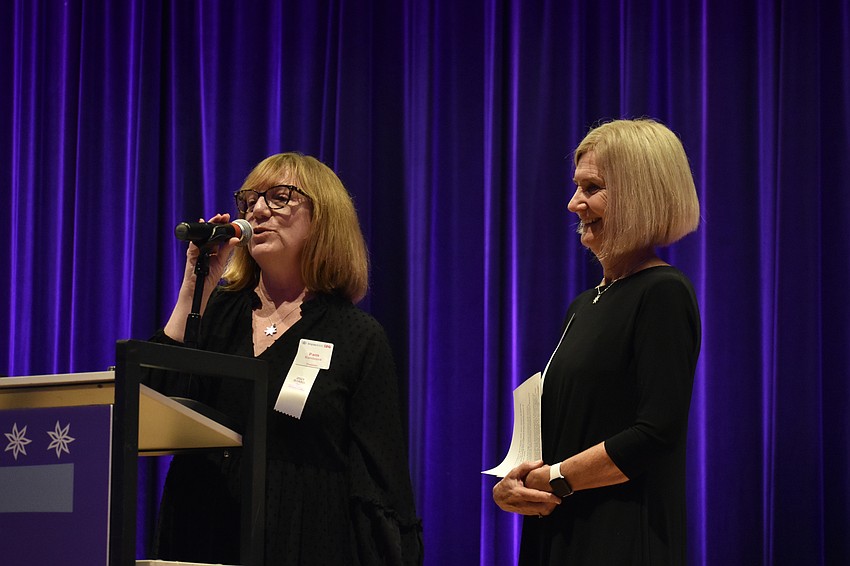 Impact100 SRQ president Pam Kandziora and focus areas director Ellen Foster address the crowd.