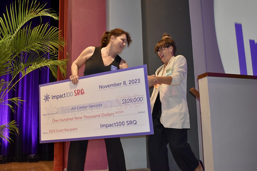 Nonprofit director Betsy Friedman presents a grant to Kinsey Robb, executive director of Art Center Sarasota.
