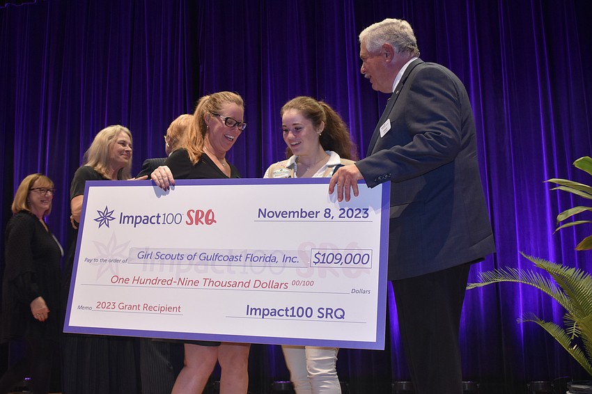 Tonya Tremitiere presents an award to girl scout Kenzie Shockey, 15, and Girl Scouts of Gulfcoast Florida board chair Richard Cyphers.