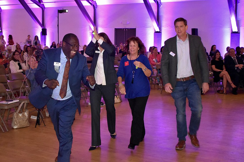 Fatherhood Program Facilitator Edwin Robinson, CEO Dr. Helene Lotman, Board Chair Kathie Roberts and Chief of Behavioral and Health Services Keith Leahey, of Jewish Family & Children's Service of the Suncoast, walk towards the stage after being announced as winners.