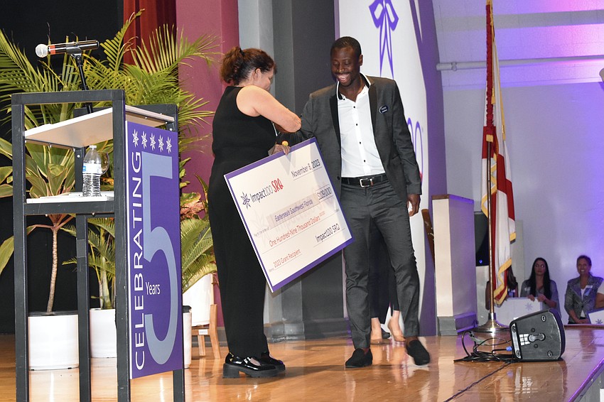Nonprofit director Betsy Friedman presents a grant to Garfield Beezer, director of food and nutrition services at Easterseals Southwest Florida.