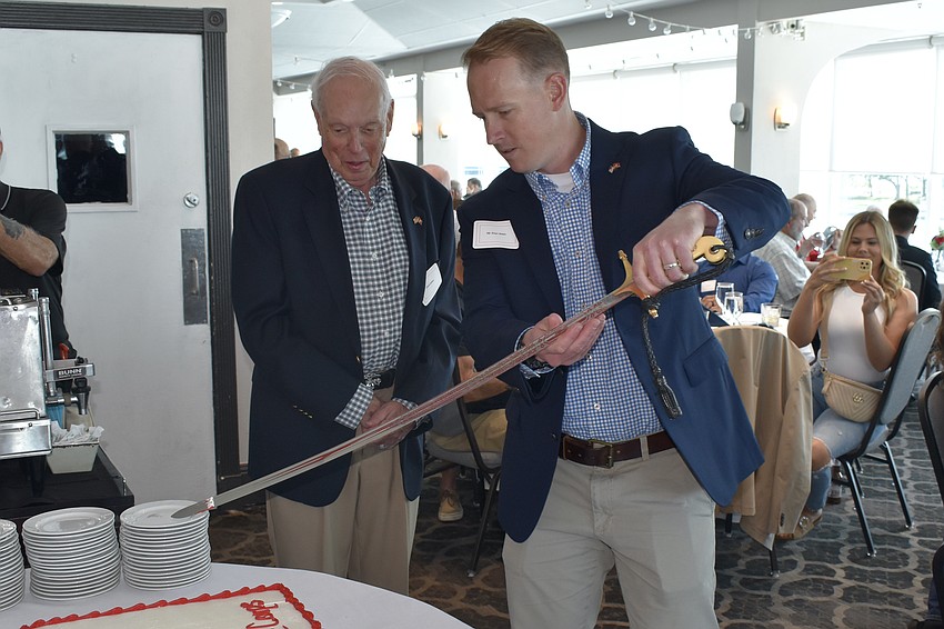 David Beliles, chairman of Observer Media Group, watches as his grandson Brian Walsh performs the ceremony of the cake cutting.