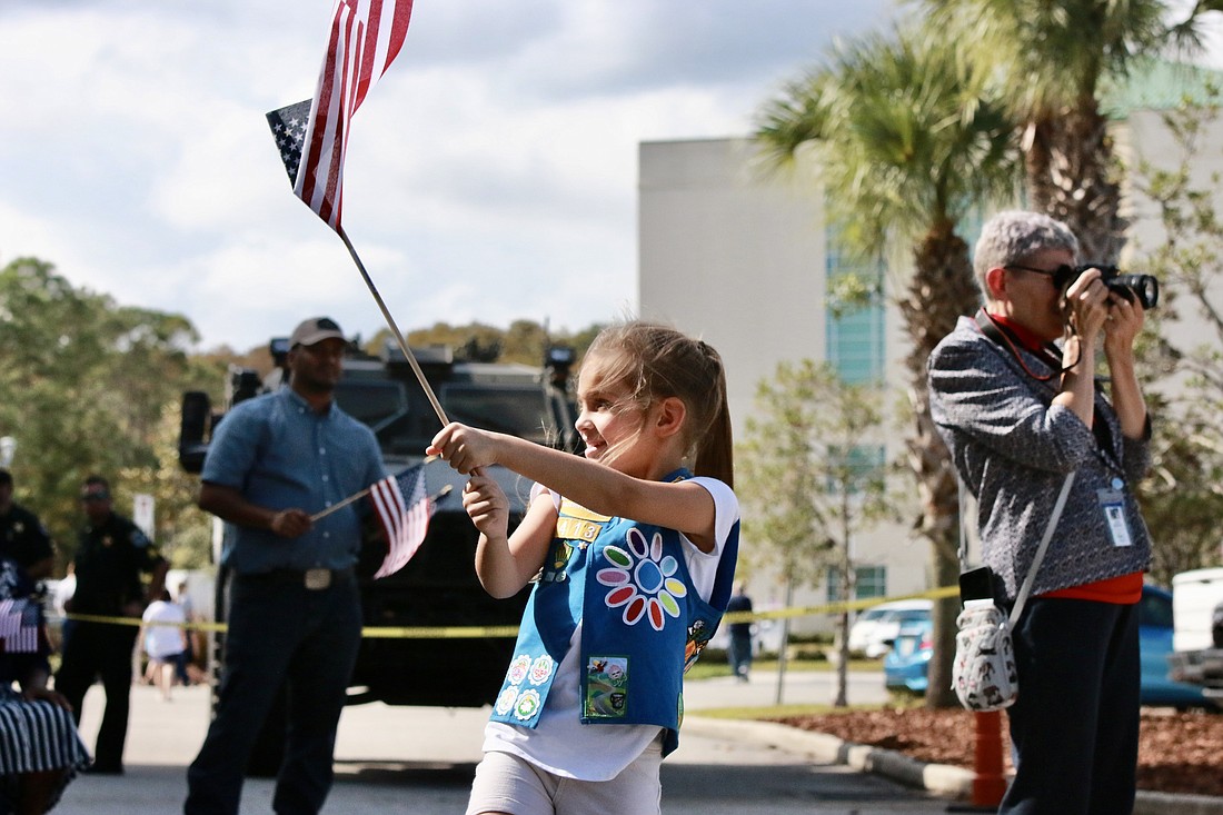 Girl Scout Stephanie Bickert waves an American Flag at the 2023 Veterans Day Ceremony. Photo by Sierra Williams