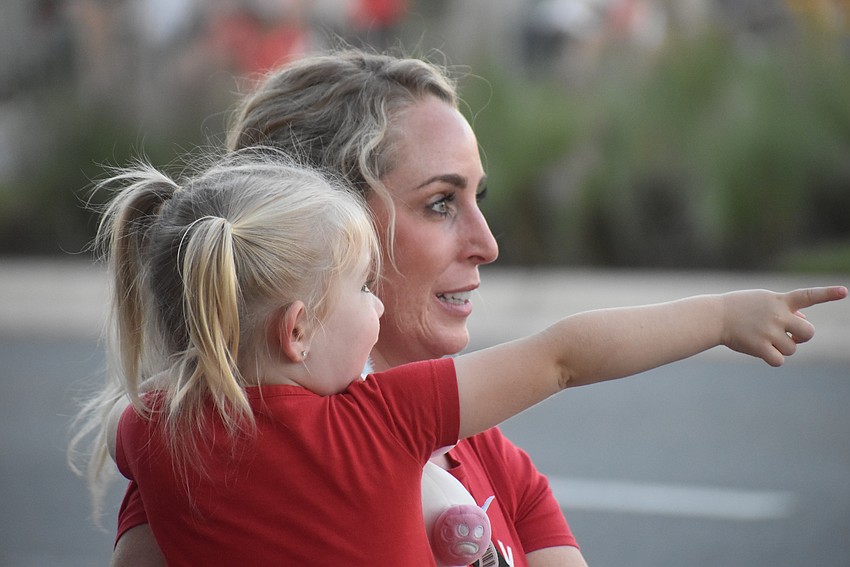 Lakewood Ranch 3-year-old Sutton Bode points out something fun to her mom Heather Bode before the Santa's Grand Arrival Parade.