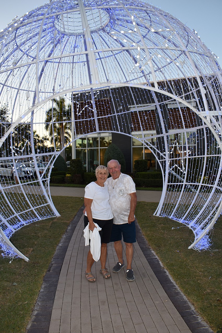 Pam and Wayne Robbins of Venice take a photo under a light-up holiday ornament.