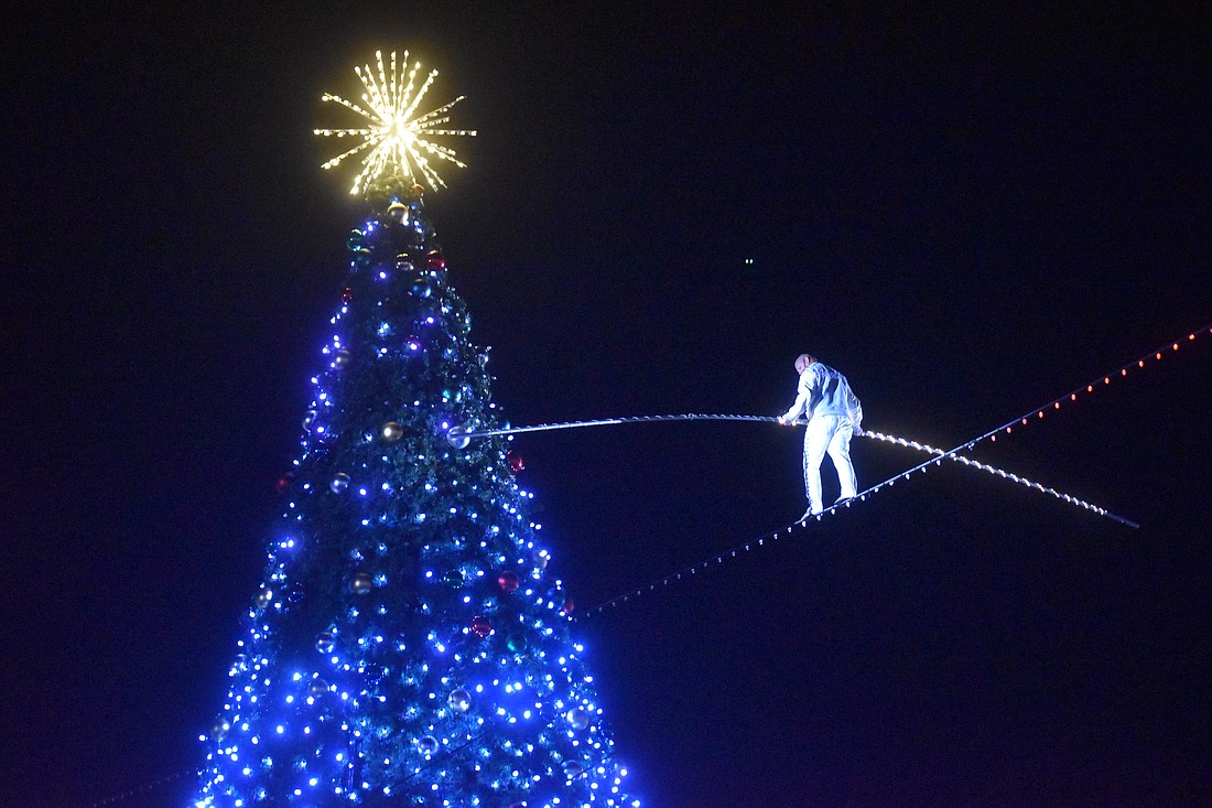 Nik Wallenda puts a charge into the crowd as well as the 50-foot Christmas Tree at University Town Center by crossing Cattlemen Road on the high wire  Nov. 11, 2023.