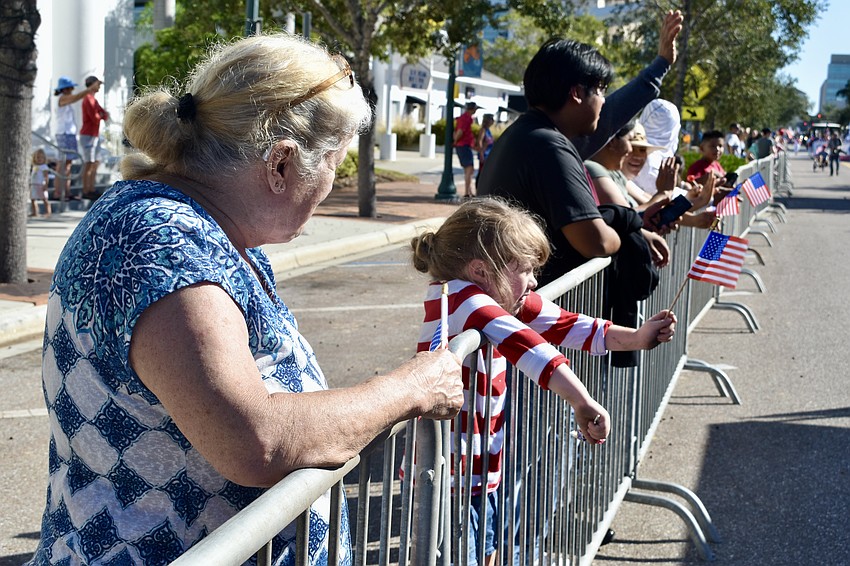 Laura Slover accompanies Aurora Muller, 5, on her first Veterans Day parade.