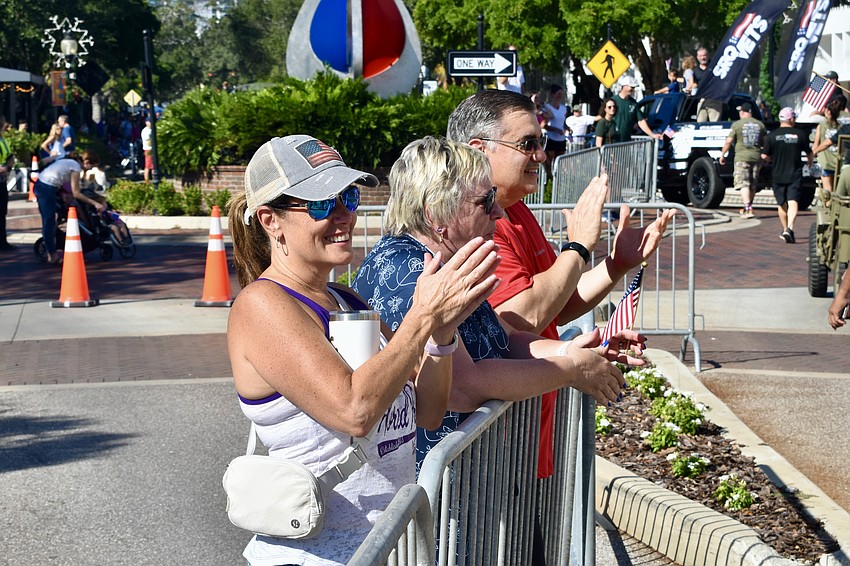 Jackie Jackson and Mark and Laura LaSpisa applaud the parade.