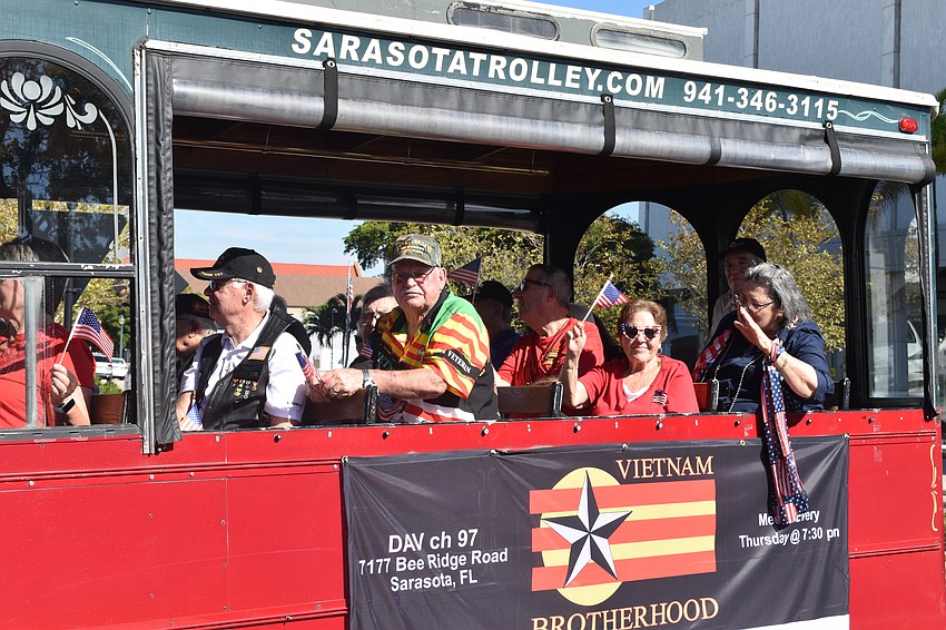 Members of Vietnam Brotherhood ride in a trolley down Main Street.