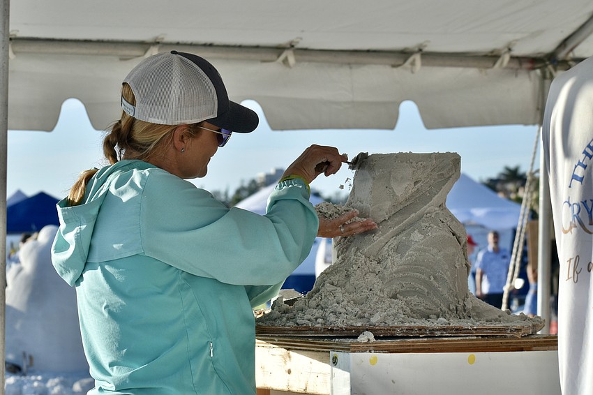 Amanda Bolduc from Maine, USA, scuplts a treefrog on a surfboard during the Quick Sand competition.